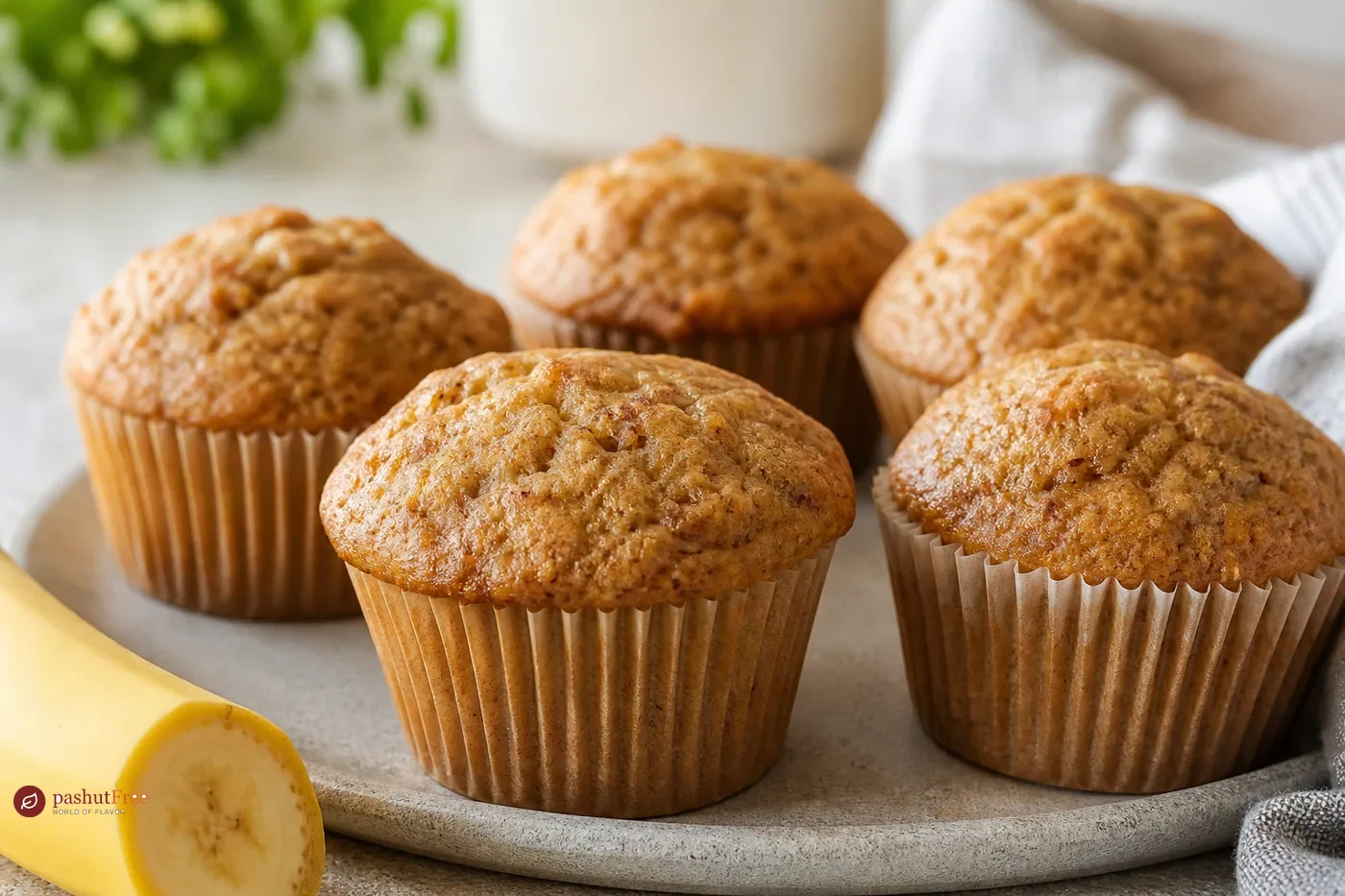 Golden moist banana muffins on a light plate